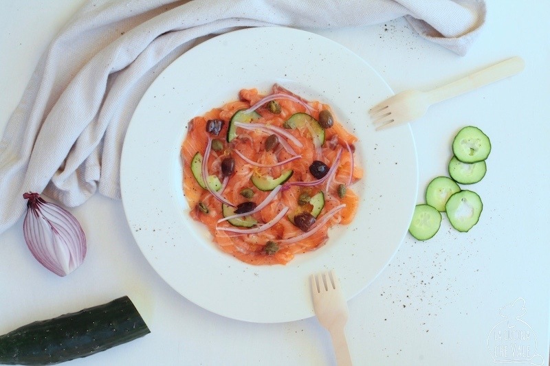 Il sashimi di salmone è un piatto fresco e perfetto per la stagione estiva, bastano pochi ingredienti: il salmone norvegese crudo, le olive, i capperi, i cetrioli e la cipolla rossa.